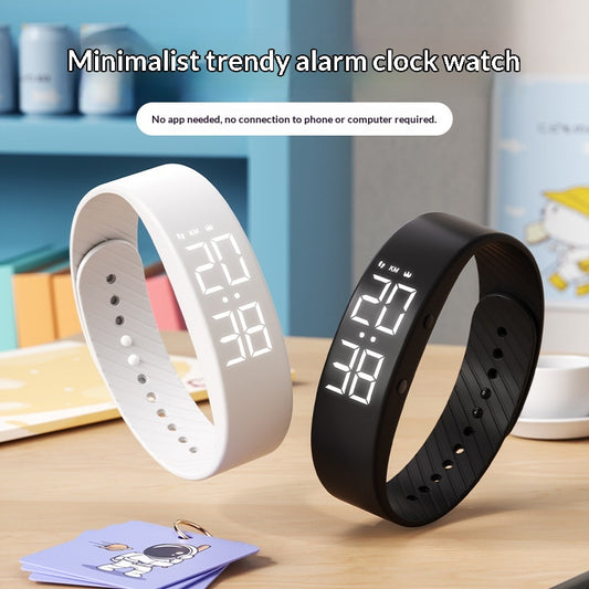 White and black vibrating alarm watches on a desk showing LED time