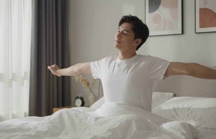 Person stretching in bed after waking